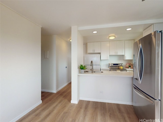 kitchen featuring light hardwood / wood-style floors, white cabinetry, stainless steel appliances, and sink