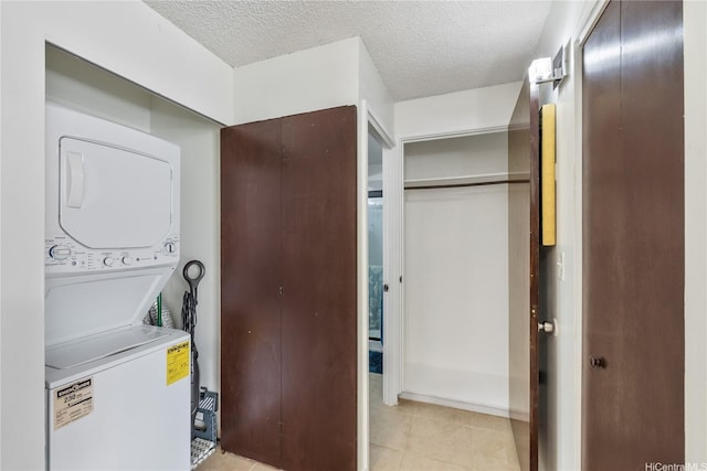 475 Atkinson Dr Unit 709, Honolulu, HI 96814 - washroom featuring light tile patterned flooring, a textured ceiling, stacked washer and dryer, and laundry area