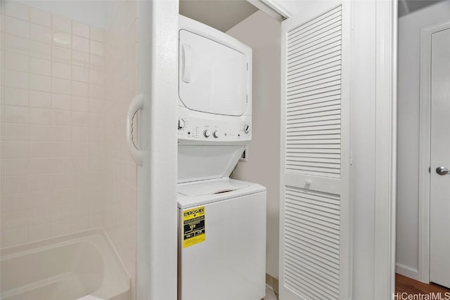 washroom featuring dark wood-type flooring and stacked washer and dryer