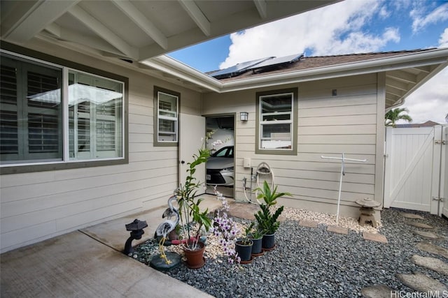 entrance to property featuring a patio area and solar panels