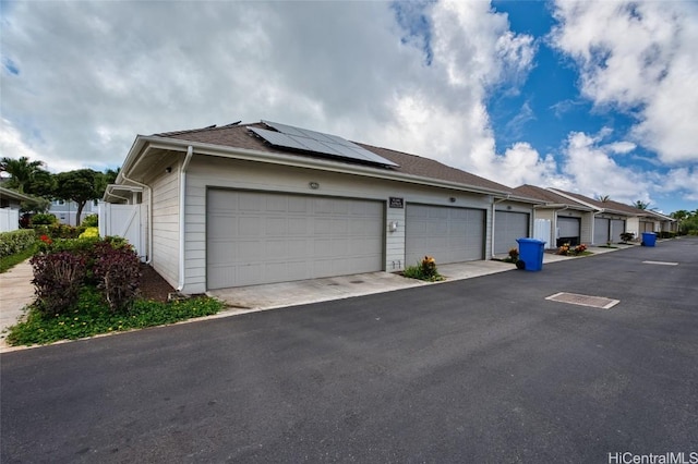 exterior space with a garage and solar panels