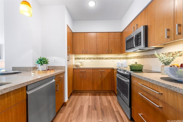 555 S St Unit 1904, Honolulu, HI 96813 - kitchen with appliances with stainless steel finishes, light wood-style flooring, brown cabinets, backsplash, and light stone counters