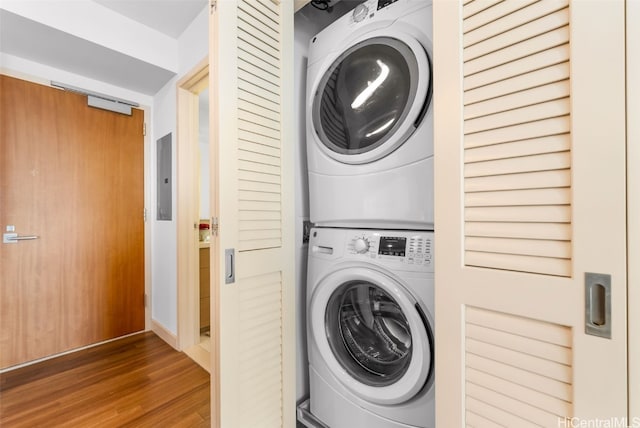 laundry area featuring hardwood / wood-style floors and stacked washing maching and dryer