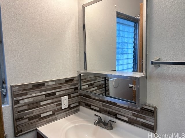 bathroom featuring vanity and backsplash