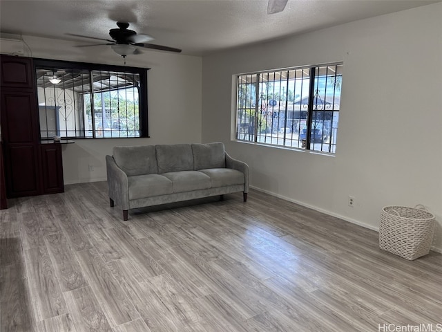 living room featuring a wealth of natural light, light hardwood / wood-style floors, and ceiling fan