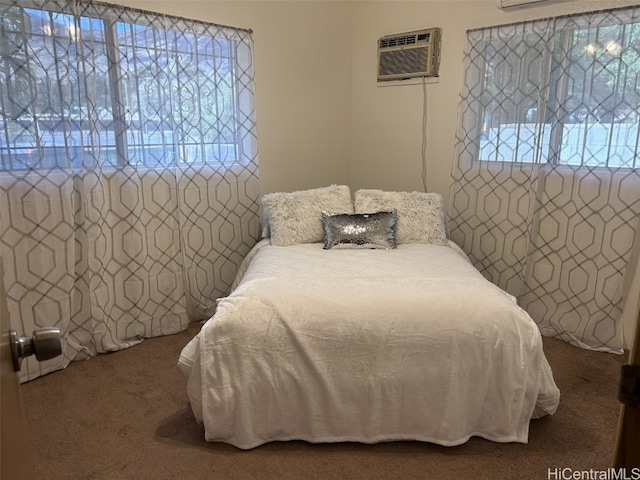 bedroom with an AC wall unit and carpet floors