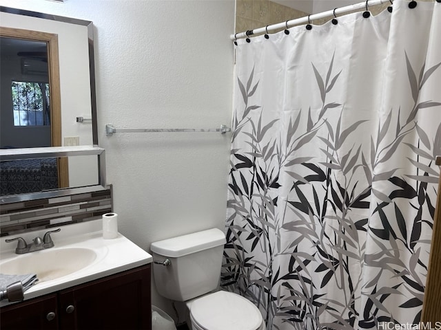 bathroom with vanity, toilet, decorative backsplash, and curtained shower