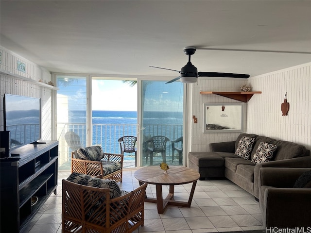 tiled living room with a water view and ceiling fan