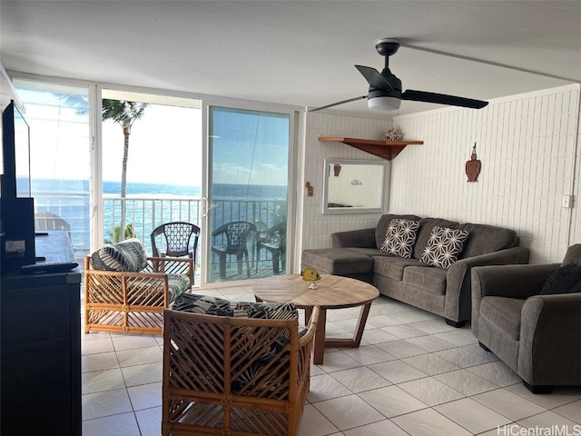 living room featuring a water view, ceiling fan, and light tile patterned flooring