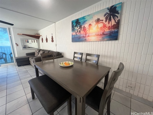 dining space featuring tile walls and light tile patterned floors