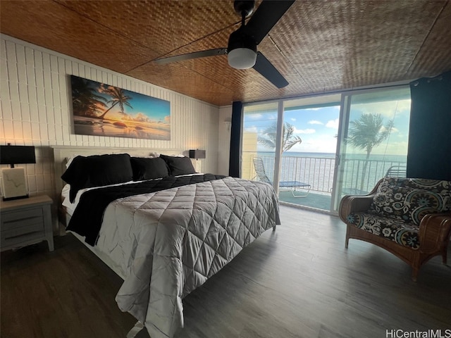 bedroom with access to outside, floor to ceiling windows, hardwood / wood-style flooring, a water view, and ceiling fan