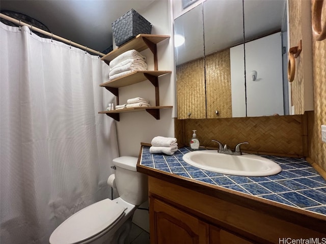 bathroom featuring vanity, toilet, and tasteful backsplash