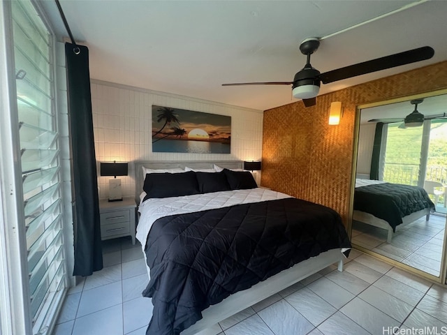 tiled bedroom featuring ornamental molding, tile walls, and ceiling fan