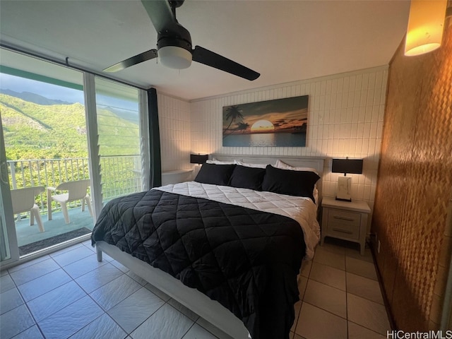 bedroom featuring tile walls, access to outside, multiple windows, and ceiling fan