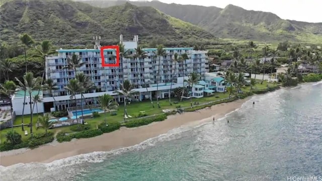 birds eye view of property with a water and mountain view and a beach view