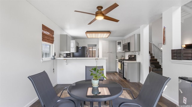 dining room with stairway, baseboards, ceiling fan, and dark wood finished floors