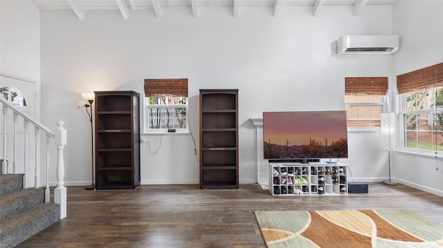living area with beam ceiling, a wall mounted AC, high vaulted ceiling, and wood finished floors