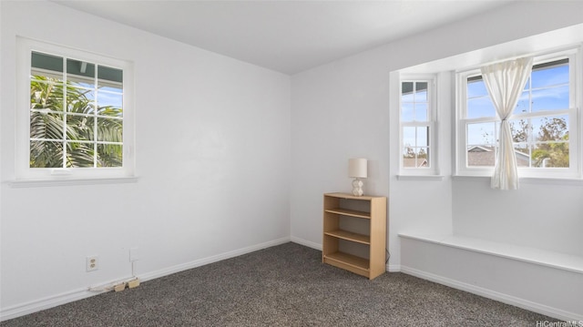 spare room featuring carpet floors and baseboards