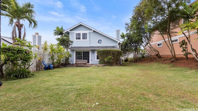 rear view of house featuring a lawn