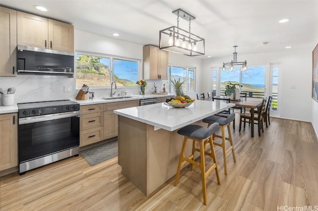 kitchen featuring a center island, light hardwood / wood-style flooring, a healthy amount of sunlight, and appliances with stainless steel finishes