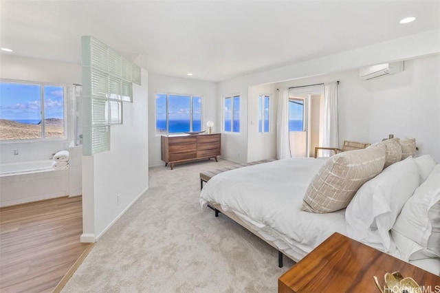 bedroom with a wall mounted air conditioner and light wood-type flooring