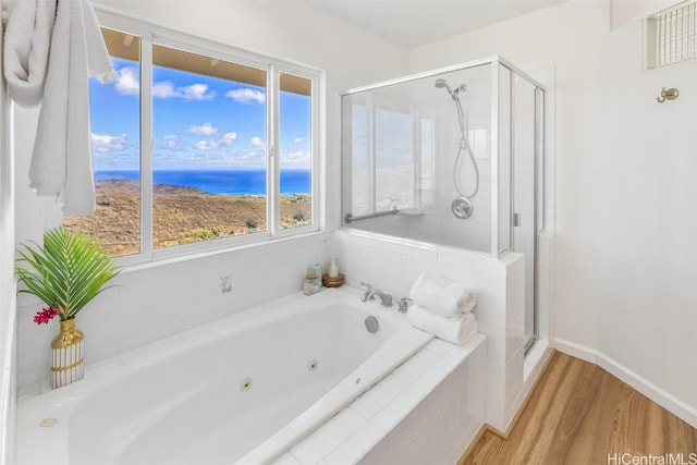 bathroom with plenty of natural light, a water view, wood-type flooring, and independent shower and bath