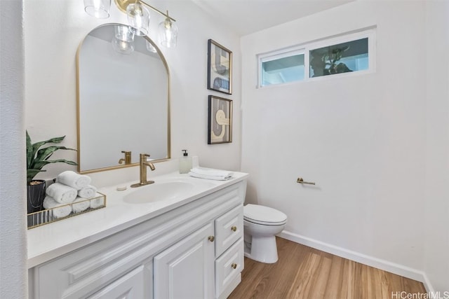 bathroom with toilet, vanity, and hardwood / wood-style flooring