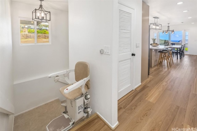 hall with hardwood / wood-style flooring and a notable chandelier