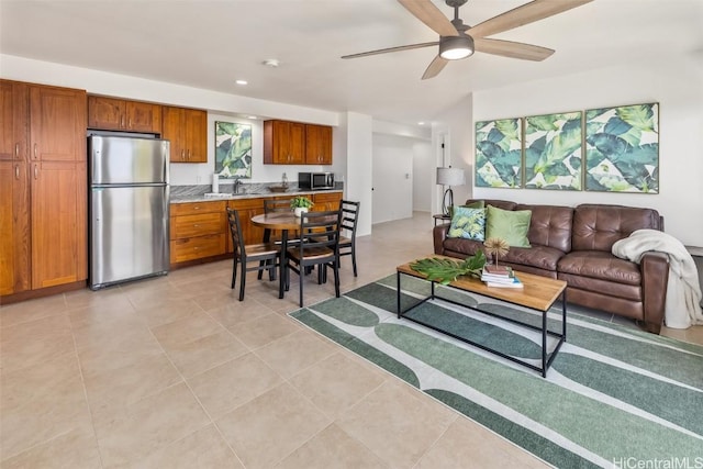 living room featuring light tile patterned floors, ceiling fan, and sink