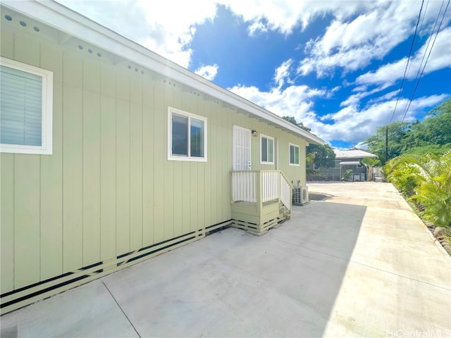 view of side of property featuring a patio area and central AC unit