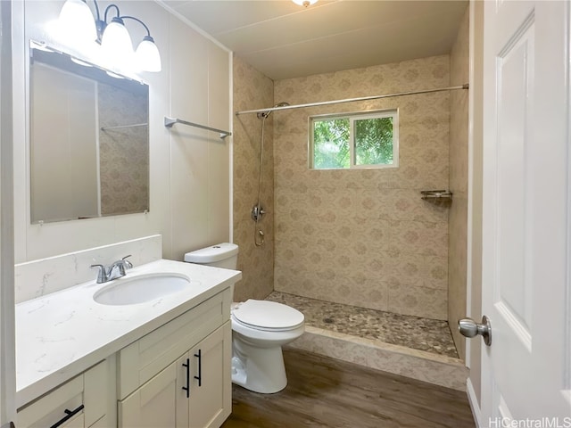 bathroom with vanity, tiled shower, wood-type flooring, and toilet