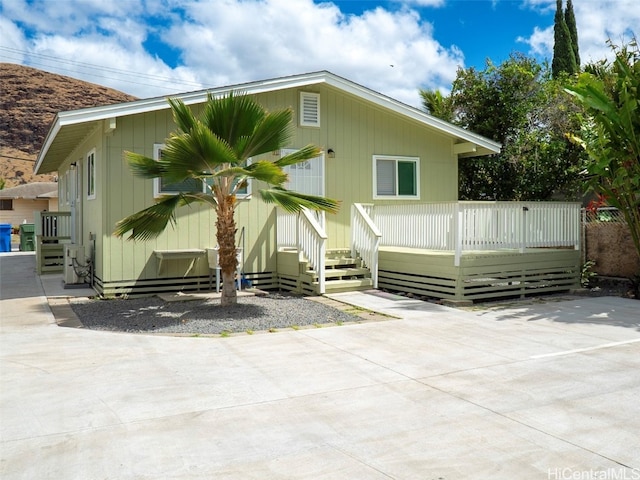 rear view of property with a wooden deck and a patio area