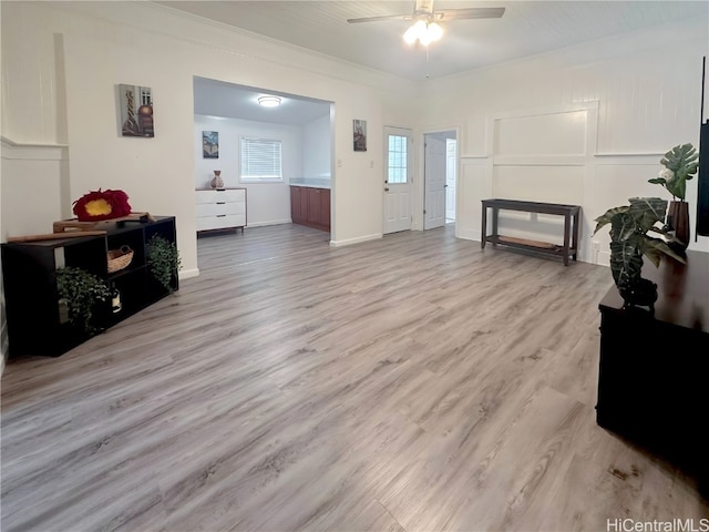 living room with light hardwood / wood-style flooring, ceiling fan, and crown molding