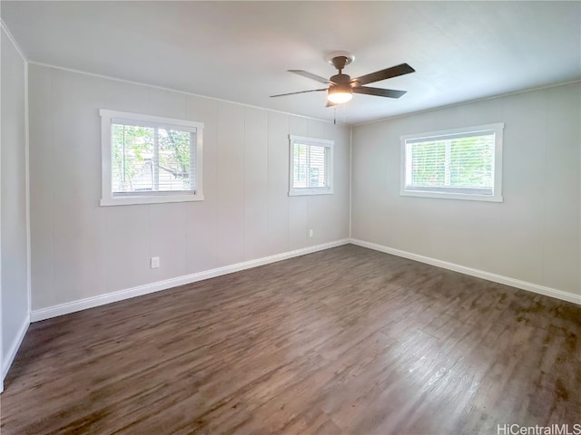 unfurnished room featuring a wealth of natural light, dark wood-type flooring, and ceiling fan