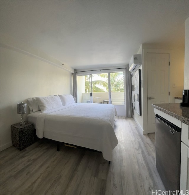 bedroom with light hardwood / wood-style floors and a wall mounted AC