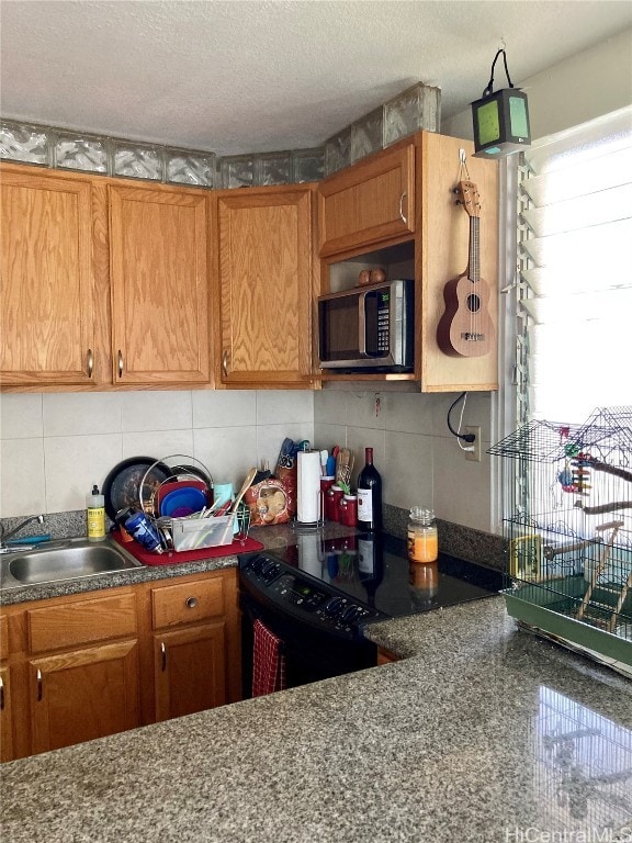 kitchen featuring a textured ceiling, black electric range oven, and sink