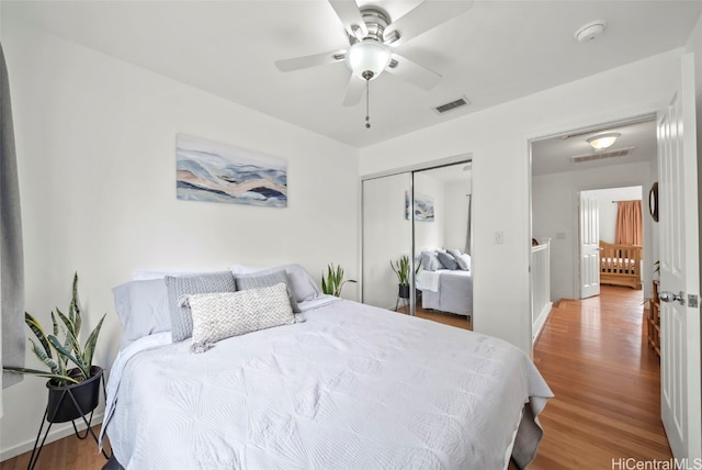 bedroom with hardwood / wood-style floors, ceiling fan, and a closet