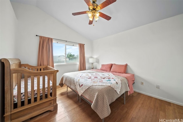 bedroom with ceiling fan, hardwood / wood-style floors, and vaulted ceiling