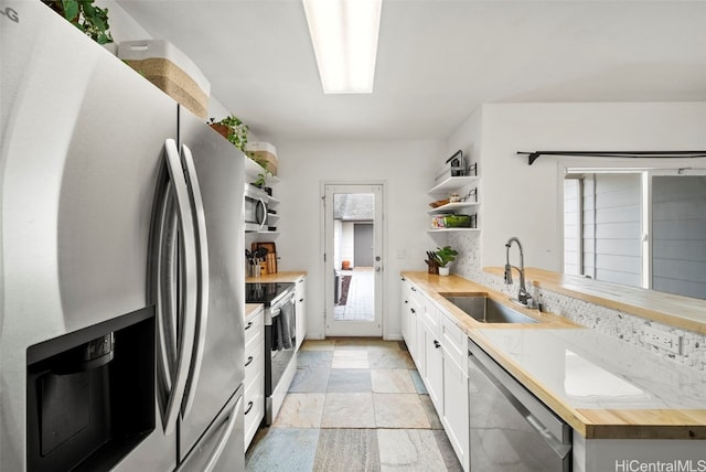 kitchen featuring butcher block countertops, white cabinets, sink, and appliances with stainless steel finishes