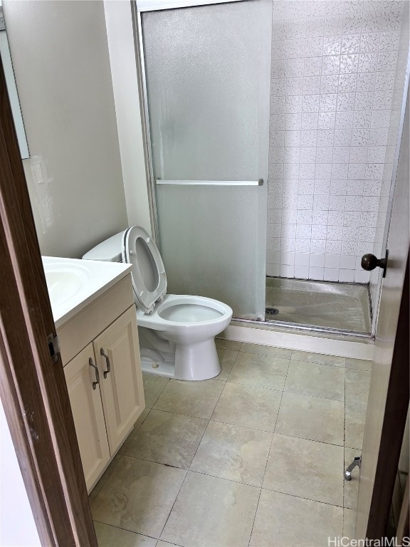 bathroom with vanity, a shower with shower door, toilet, and tile patterned flooring