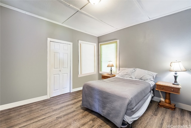 bedroom featuring a closet, ornamental molding, and hardwood / wood-style floors