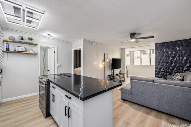 kitchen with ceiling fan, light hardwood / wood-style flooring, a center island, white cabinetry, and stainless steel electric range