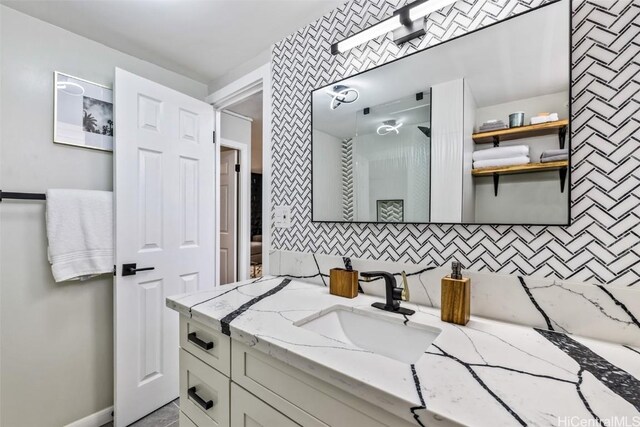 bathroom featuring vanity and tasteful backsplash