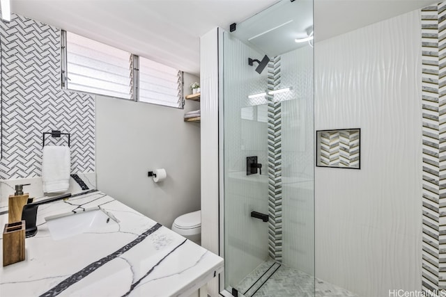 bathroom featuring vanity, toilet, and a tile shower