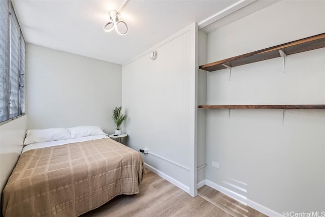 bedroom with baseboards and wood finished floors