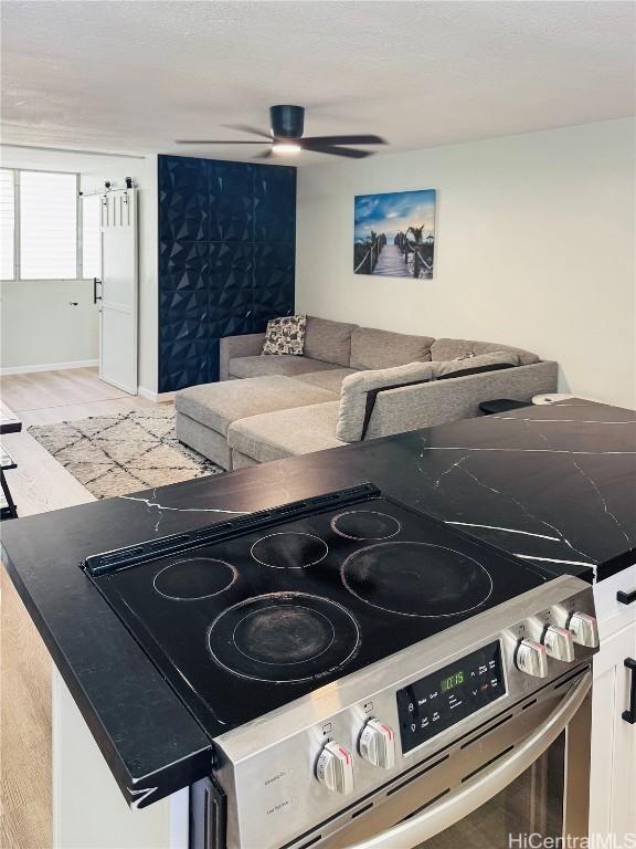 kitchen with electric stove, light wood-type flooring, and a ceiling fan