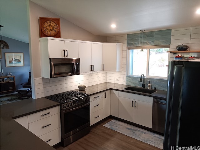 kitchen with white cabinets, tasteful backsplash, vaulted ceiling, black appliances, and sink