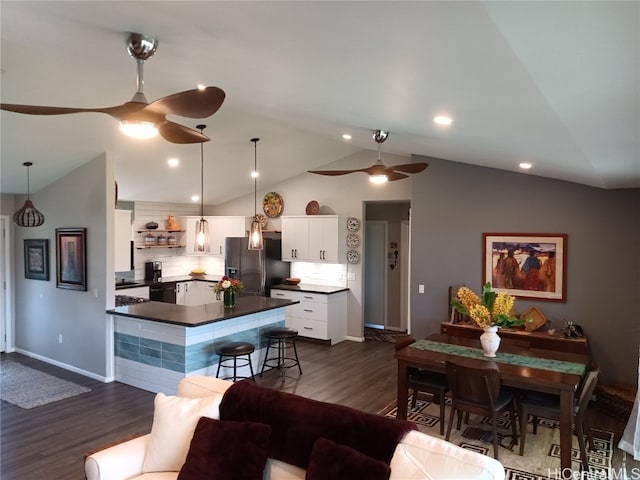 kitchen with lofted ceiling, dark hardwood / wood-style floors, stainless steel fridge with ice dispenser, decorative light fixtures, and white cabinets