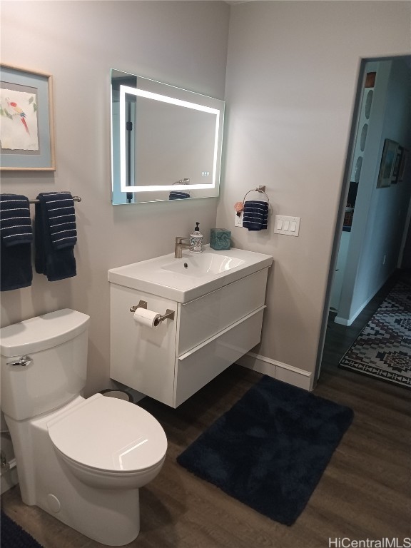 bathroom with vanity, wood-type flooring, and toilet