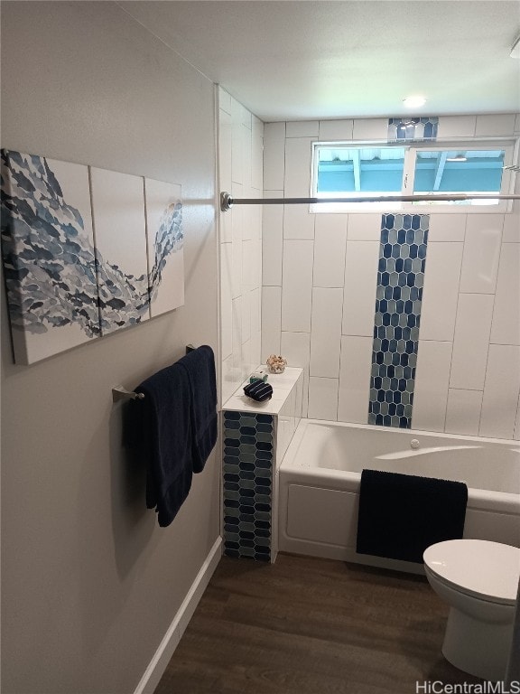 bathroom featuring tiled shower / bath, hardwood / wood-style flooring, toilet, and plenty of natural light